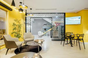 Hotel Cetina Murcia في مورسية: مطعم بجدران صفراء وطاولات وكراسي