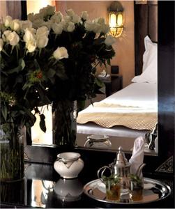 a bedroom with a bed and a table with a vase of flowers at Mont Gueliz in Marrakech