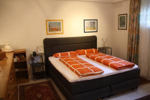ein Schlafzimmer mit einem Bett mit orangefarbenen Kissen darauf in der Unterkunft Ferienwohnung Inga in Spabrücken