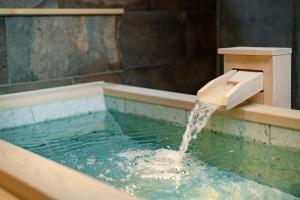 a water fountain in a pool of water at MATERIAL Fuchomae in Kyoto