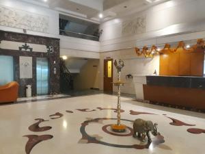 a lobby with an elephant and a sign on the floor at The Samrat Hotel near Pune Railway Station in Pune