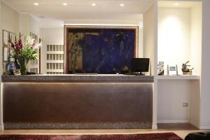 recepción en un vestíbulo con una pintura en Hotel City, en Piacenza