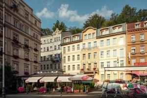 powóz ciągnięty przez konia przed budynkiem w obiekcie Hotel Malta w Karlowych Warach