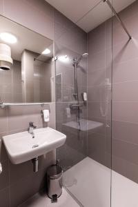a bathroom with a sink and a glass shower at Harmony Club Hotel in Ostrava