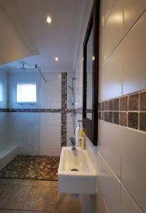 a white bathroom with a sink and a shower at Bellamente Sirene in Gansbaai
