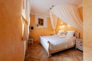 a bedroom with a bed with white sheets and curtains at Boutique Hotel Romantick in Český Krumlov