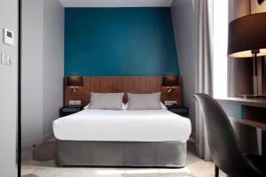 1 dormitorio con 1 cama y 1 silla en Montparnasse Alésia en París