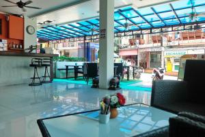 a lobby with a glass table with flowers on it at Calypso Patong House in Patong Beach