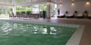 a swimming pool with green water in a house at Landhotel Stähle in Schüttorf