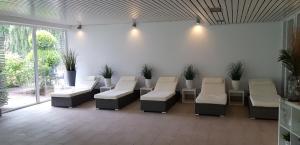 a waiting room with white chairs and plants at Landhotel Stähle in Schüttorf