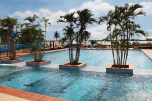 a swimming pool with palm trees in a resort at The Federal Palace Hotel and Casino in Lagos