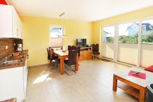 een keuken en eetkamer met een tafel en stoelen bij Ferienhaus Sinha_SOMM in Ostseebad Karlshagen