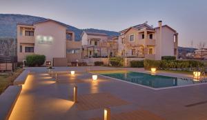 a villa with a swimming pool in front of a house at Ellopia Point Hotel in Ioannina