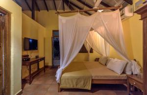 a bedroom with a bed with a mosquito net at SaffronStays Villa 270, Dapoli in Dapoli