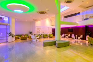 a lobby with chairs and a green ceiling at Limanaki Beach Hotel & Suites in Ayia Napa