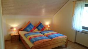 a bedroom with a bed with two colorful pillows at Ferienhaus Günztal, Fam. Botzenhart in Ellzee