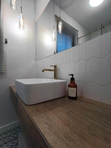 a bathroom with a white sink and a bottle of soap at Come&Stay apartments Wola in Warsaw