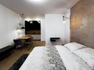 a bedroom with a large bed and a table at Come&Stay apartments Wola in Warsaw