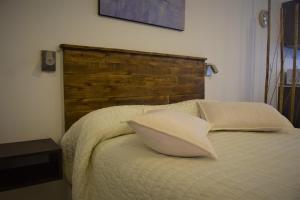 1 cama con 2 almohadas y cabecero de madera en New Apartment in Recoleta en Buenos Aires