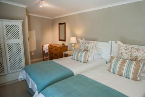ein Schlafzimmer mit 2 Betten und einem Tisch mit einer Lampe in der Unterkunft Sneezewood Farm Bed&Breakfast and Self-Catering Cottage in Dundee