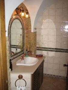 un baño con lavabo y espejo en Casa Rural La Villa, en Castro del Río 20 fotos más