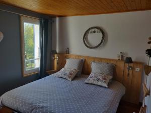 a bedroom with a bed with two pillows and a window at Gîte de Champflorin in Seyne