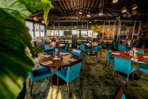 a restaurant with blue chairs and tables in a room at Hotel De Bonte Wever Assen in Assen