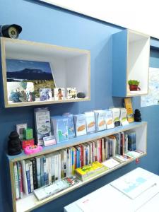 a book shelf filled with books in a room at Slow Citi Guest House -슬로시티게스트하우스 in Seogwipo