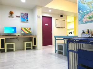 a waiting room with a desk and a red door at Slow Citi Guest House in Seogwipo