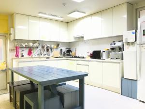a large kitchen with a blue table in it at Slow Citi Guest House -슬로시티게스트하우스 in Seogwipo