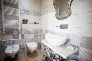 een badkamer met een wastafel, een toilet en een spiegel bij The Railway 74 in La Spezia