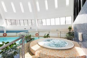 uma banheira de hidromassagem no meio de um edifício com piscina em AZIMUT Hotel Olympic Moscow em Moscovo