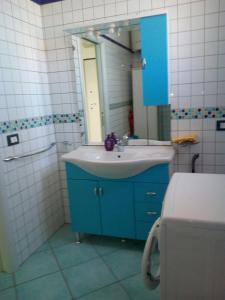 a bathroom with a blue sink and a mirror at APPARTAMENTO CON TERRAZZA SUL MARE in Sciacca