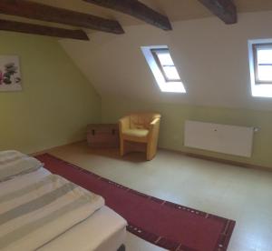 a attic room with a bed and a chair at Ferienwohnung Wilde - Holzkamp in Itzehoe