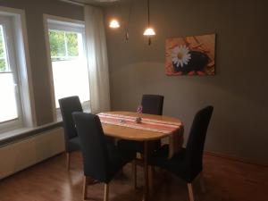 a dining room with a wooden table and chairs at Ferienwohnung Wilde - Holzkamp in Itzehoe