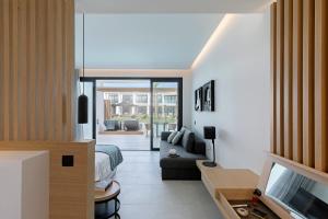 een woonkamer met een bank en een televisie bij D' Andrea Lagoon All Suites - Adults Only in Marmari