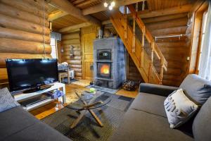 a living room with a fireplace in a log cabin at Vacation Home Tulikallio in Suonenjoki
