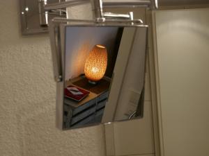 un espejo colgando de una pared con una lámpara dentro en Ferienhaus Knodel, en Sachsenheim
