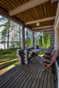 une terrasse couverte en bois avec une table et des chaises. dans l'établissement Vacation Home Tulikallio, à Suonenjoki