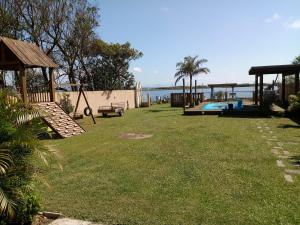 podwórko z placem zabaw i basenem w obiekcie Casa na beira da lagoa com piscina e rampa para embarcações w mieście Tramandaí
