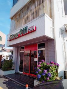 a slow onion store with flowers in front of it at Slow Citi Guest House in Seogwipo