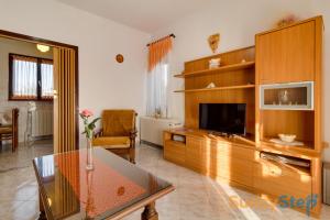 un salon avec une télévision et une table dans l'établissement Apartment Sankovic with a private pool, à Svetvinčenat
