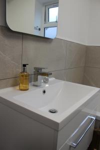 a bathroom sink with a yellow soap bottle on it at Fabulous One Bedroom Apartment in Ripon City Centre in Ripon +23 photos