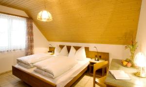 a bedroom with a bed and a desk and a window at Hotel Landgasthof Hirschen in Ramsen