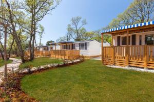 una fila de cabañas en un parque con un patio en Albatross Mobile Homes on Naturist Solaris Camping Resort FKK en Poreč