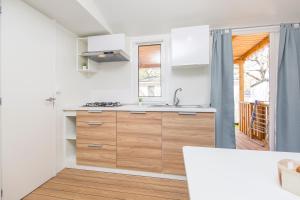 a kitchen with a sink and a stove at Albatross Mobile Homes on Naturist Solaris Camping Resort FKK in Poreč