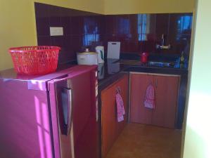 una cucina con frigorifero rosso e lavandino di Avalon Inn a Mandrem