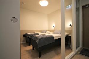 1 dormitorio con 2 camas y espejo en Forenom Aparthotel Varkaus, en Varkaus