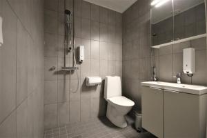 La salle de bains est pourvue de toilettes, d'une douche et d'un lavabo. dans l'établissement Forenom Aparthotel Varkaus, à Varkaus