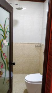 uma casa de banho com um WC e um chuveiro em Akiri Surf Retreat em Thulusdhoo
